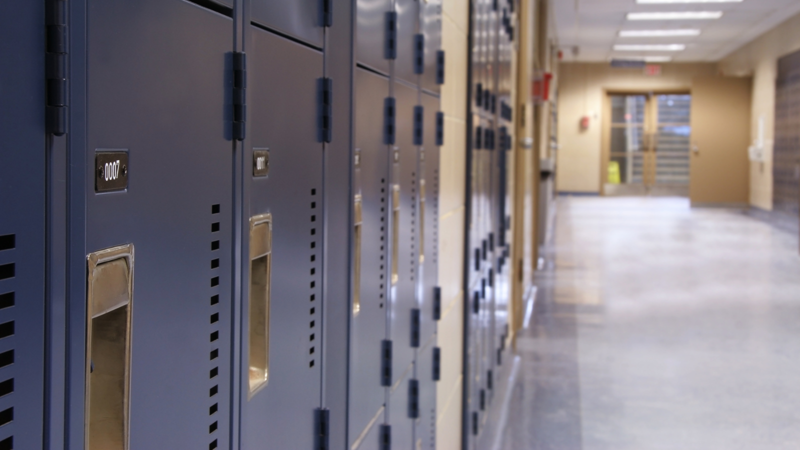 A hallway lined with dark blue metal lockers